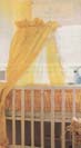 Yellow canopy attached to a stand which is clamped to the frame of a crib.
